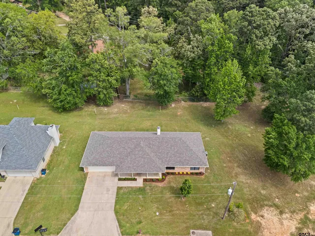 an aerial view of a house with swimming pool and a yard