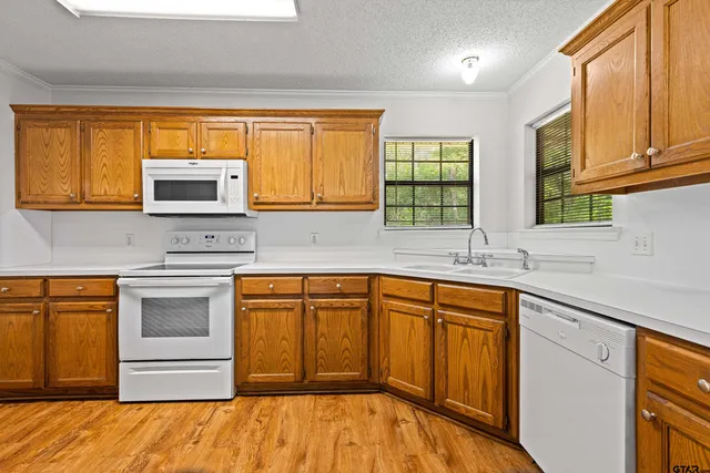 a kitchen with stainless steel appliances granite countertop a stove a sink and a microwave