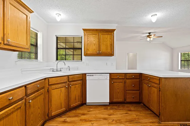 a kitchen with stainless steel appliances granite countertop a sink and cabinets with wooden floor