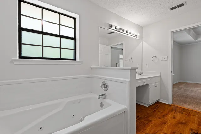 a bathroom with a tub sink and mirror