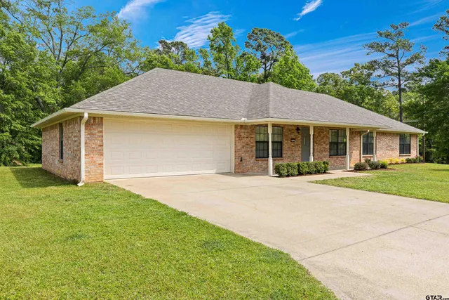 a front view of a house with a yard and potted plants