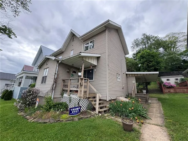 a front view of a house with a garden and plants
