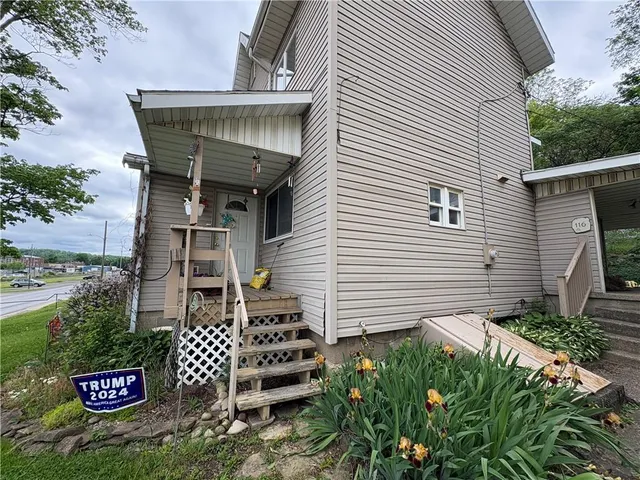 a wooden house with table and chairs in front of it