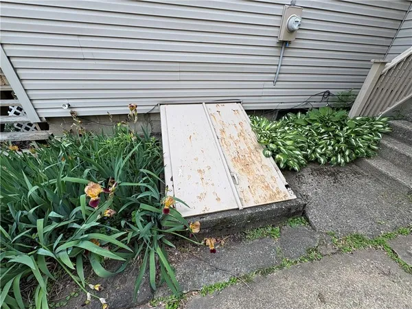 a view of a yard with plants and a wooden deck