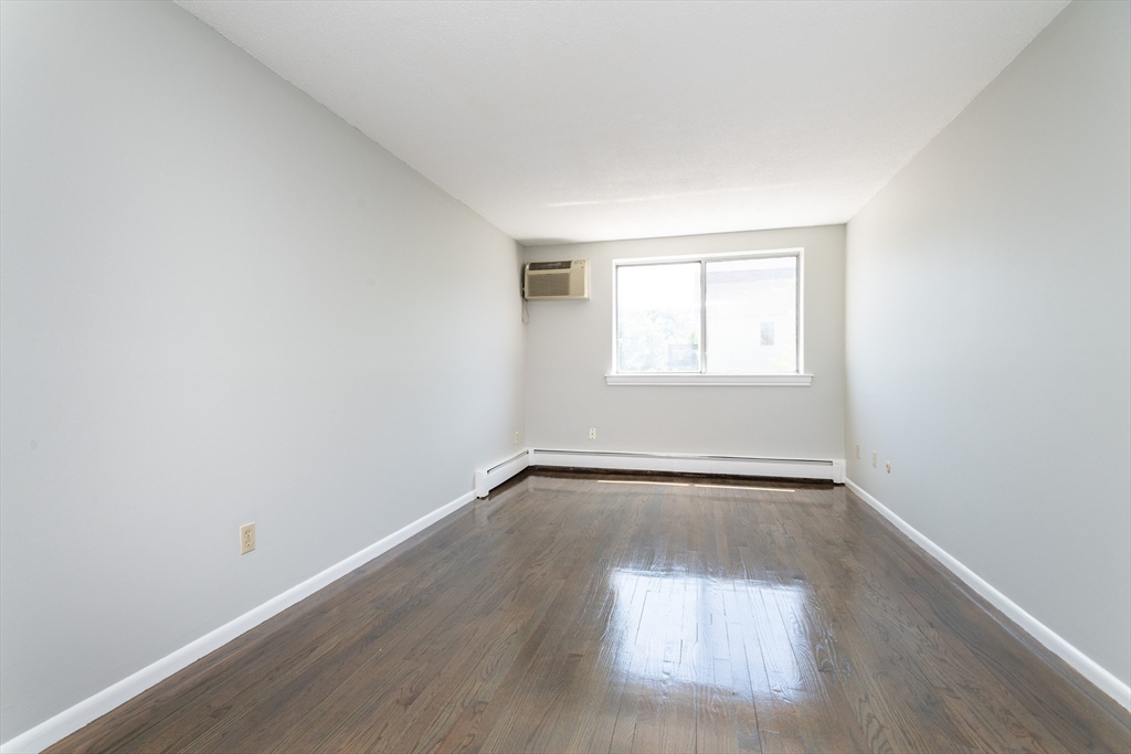 14 Murdock Street, Unit 28 Somerville, MA 02145 - Photo 3 of 14 an empty room with wooden floor and windows