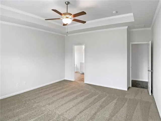 a view of an empty room and chandelier fan