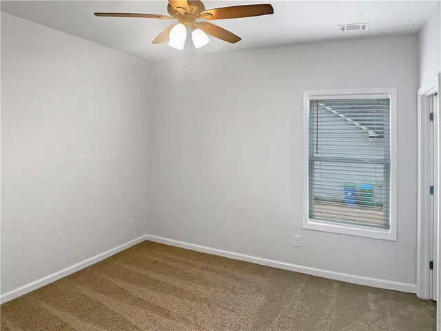 an empty room with a window and a fan