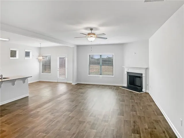 an empty room with windows and fireplace