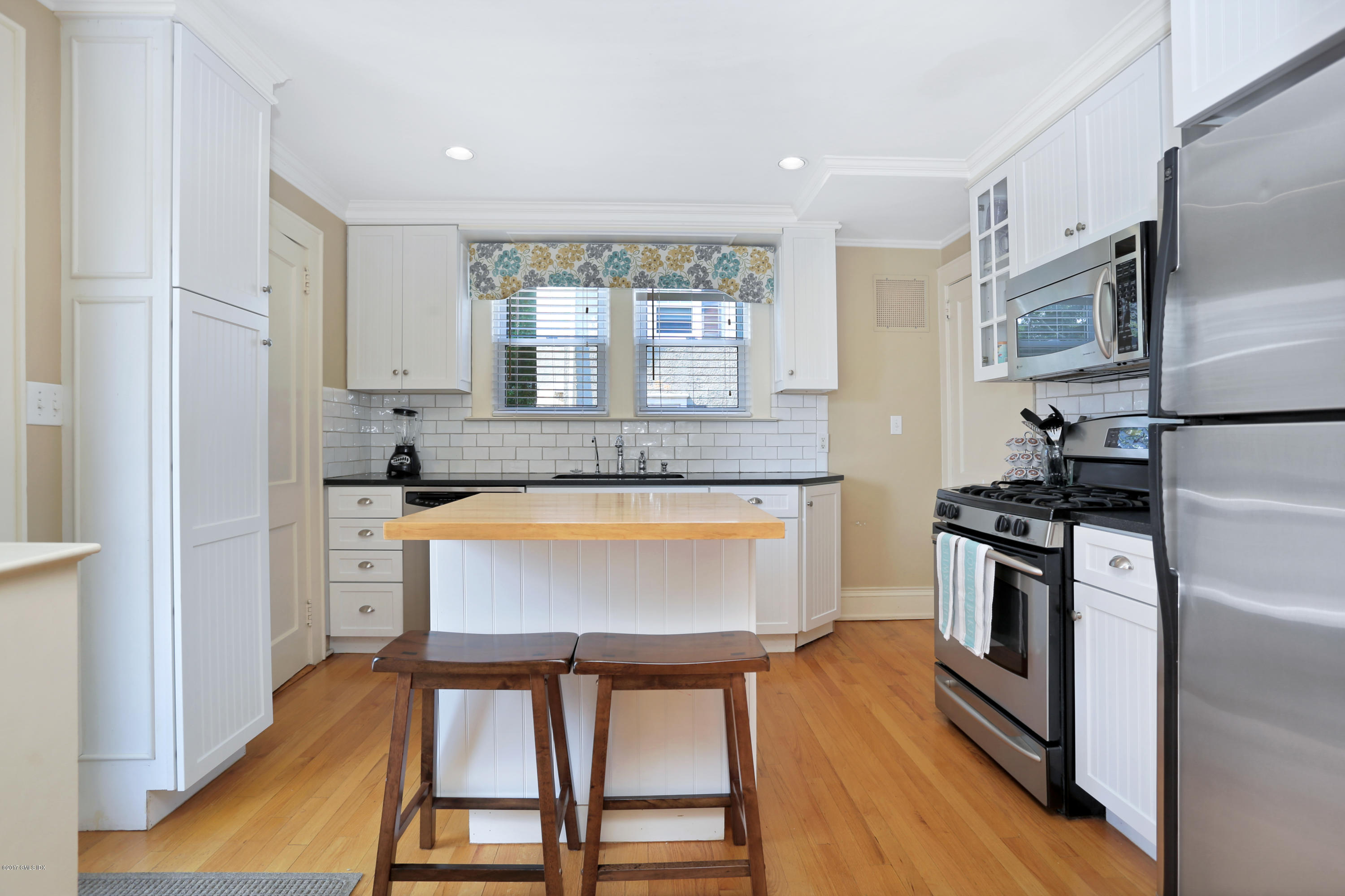 27 Pleasant Street Cos Cob, CT 06807 - Photo 9 of 21 a kitchen with kitchen island a large counter top space stainless steel appliances and a window