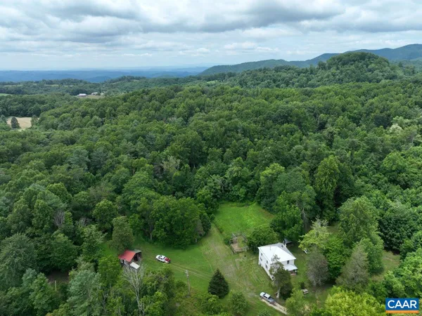 a backyard of a house with lots of green space and mountains