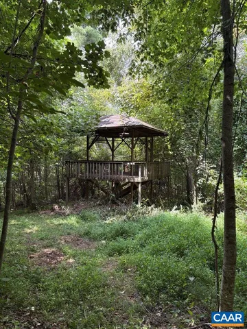 a view of backyard with a barn and large trees