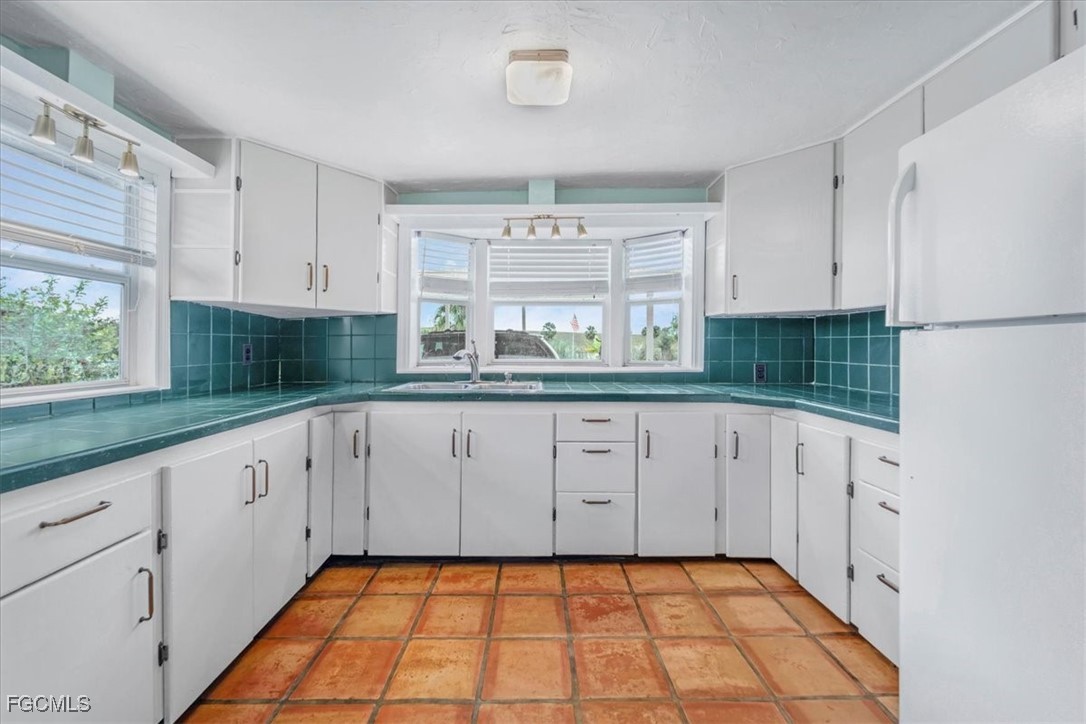 1083 Sunset Strip Moore Haven Okeechobee, FL 34974 - Photo 12 of 48 a kitchen with granite countertop white cabinets and window