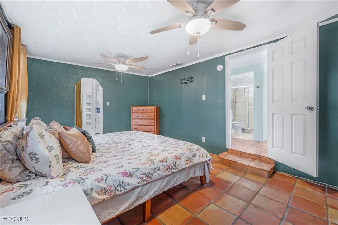 1083 Sunset Strip Moore Haven Okeechobee, FL 34974 - Photo 17 of 48 a bedroom with a large bed and a chandelier