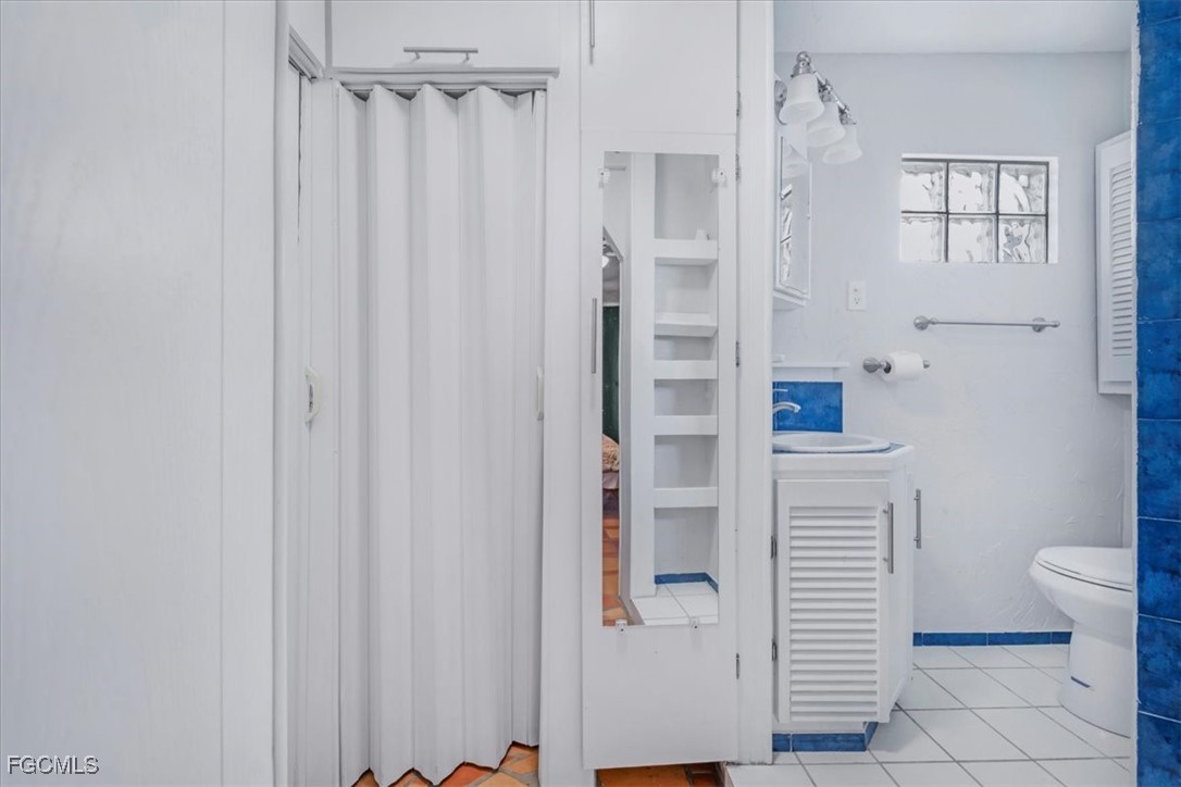 1083 Sunset Strip Moore Haven Okeechobee, FL 34974 - Photo 19 of 48 a bathroom with a shower curtain and a toilet