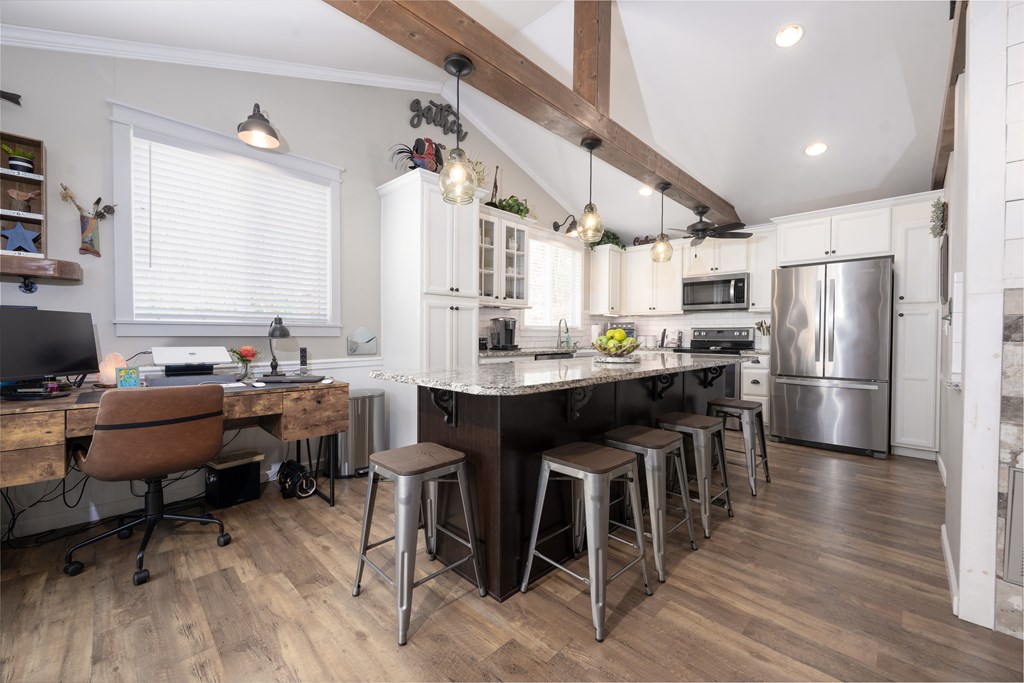 3301 Ellington Road Hayesville, NC 28904 - Photo 7 of 31 a kitchen with stainless steel appliances a dining table chairs refrigerator and sink
