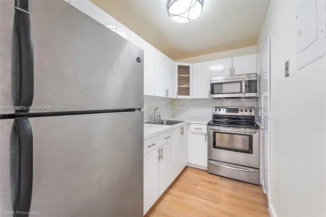 a kitchen with stainless steel appliances and white cabinets