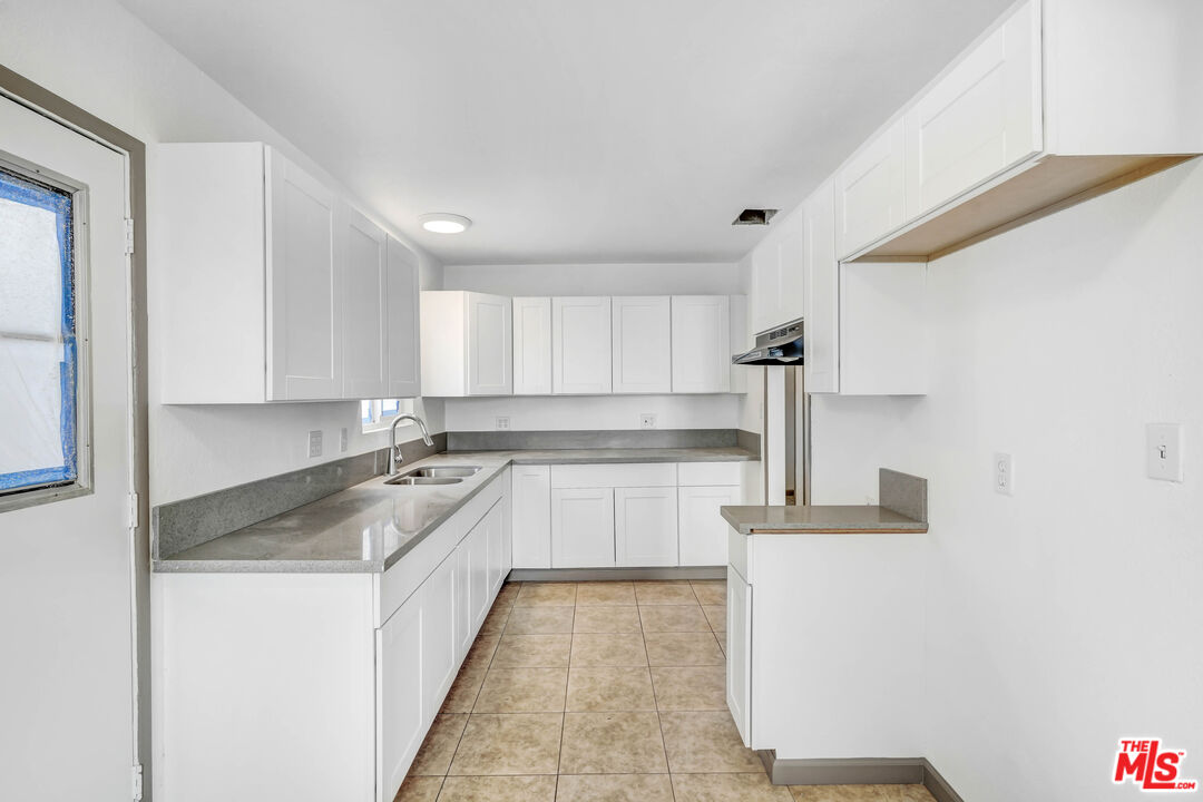 5351 Odell Street Riverside, CA 92509 - Photo 4 of 10 a kitchen with granite countertop a sink and white cabinets