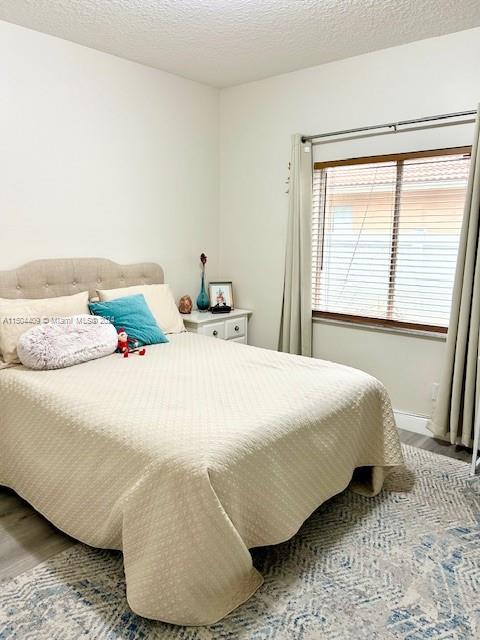 16110 Southwest 6th Street Pembroke Pines, FL 33027 - Photo 23 of 92 a bedroom with a bed and wooden floor