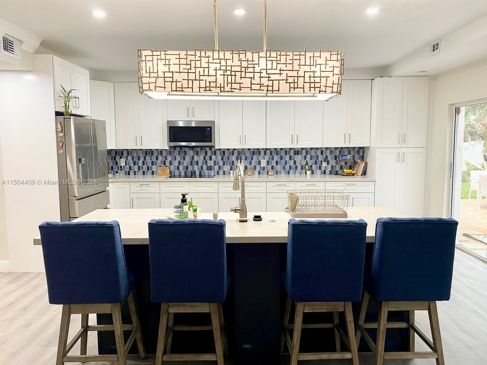 16110 Southwest 6th Street Pembroke Pines, FL 33027 - Photo 68 of 92 a kitchen with a dining table chairs and a refrigerator