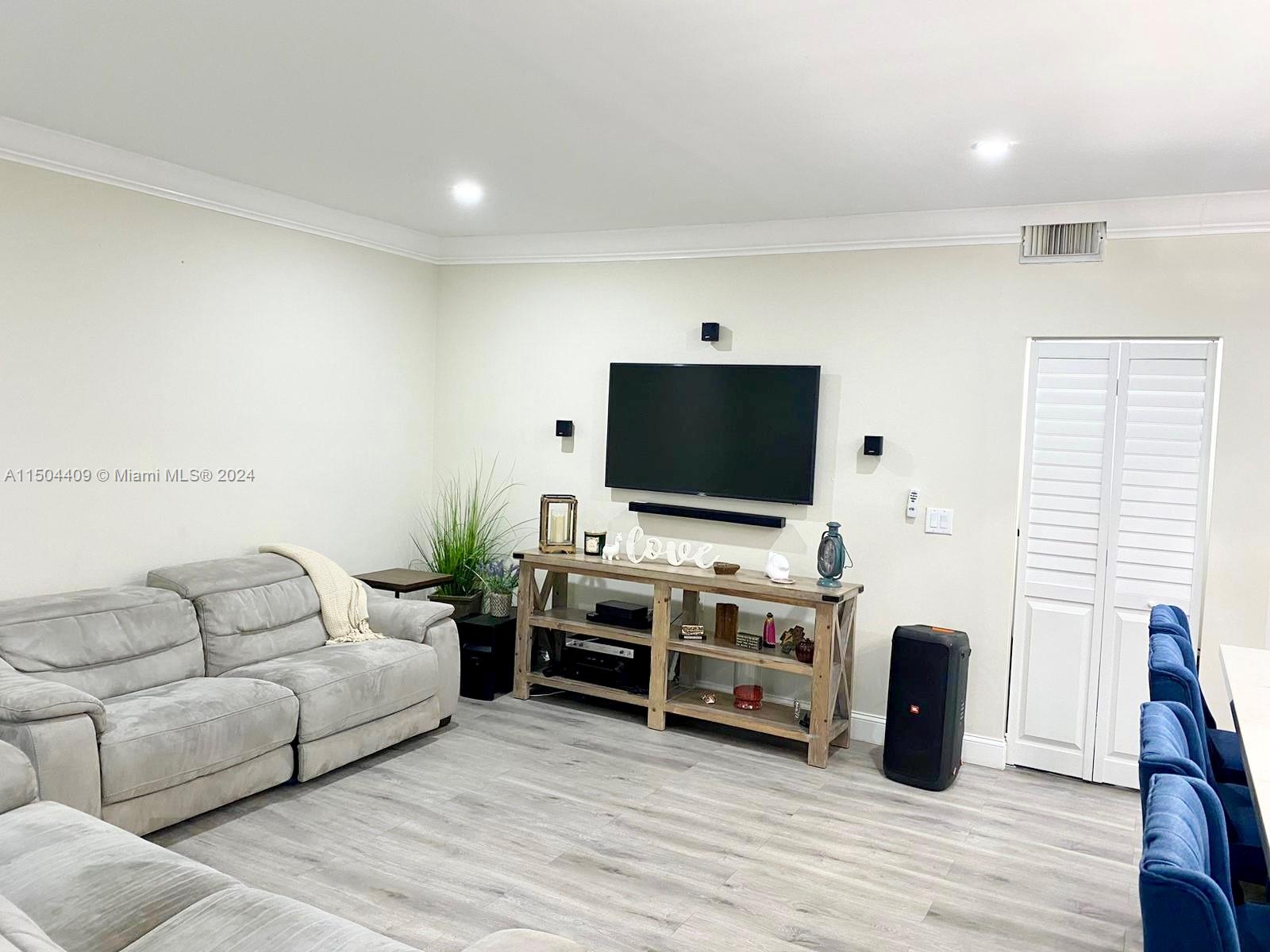 16110 Southwest 6th Street Pembroke Pines, FL 33027 - Photo 72 of 92 a living room with furniture and a flat screen tv