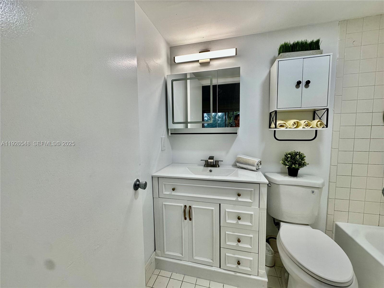 13455 Southwest 9th Court, Unit 216J Pembroke Pines, FL 33027 - Photo 18 of 66 a bathroom with a toilet a sink and mirror