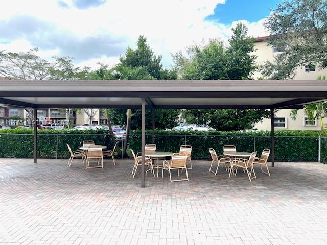 13455 Southwest 9th Court, Unit 216J Pembroke Pines, FL 33027 - Photo 37 of 66 a view of a patio with table and chairs potted plants and floor to ceiling window