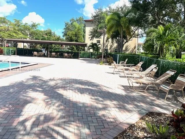 a view of a patio with table and chairs potted plants with floor to ceiling window