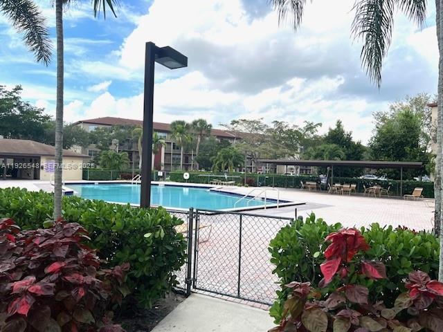 13455 Southwest 9th Court, Unit 216J Pembroke Pines, FL 33027 - Photo 40 of 66 a view of a swimming pool with a yard and a fountain