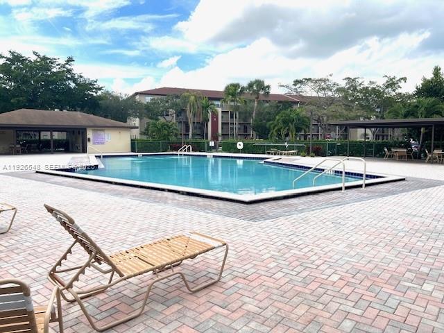 13455 Southwest 9th Court, Unit 216J Pembroke Pines, FL 33027 - Photo 43 of 66 a view of a swimming pool with a lounge chairs