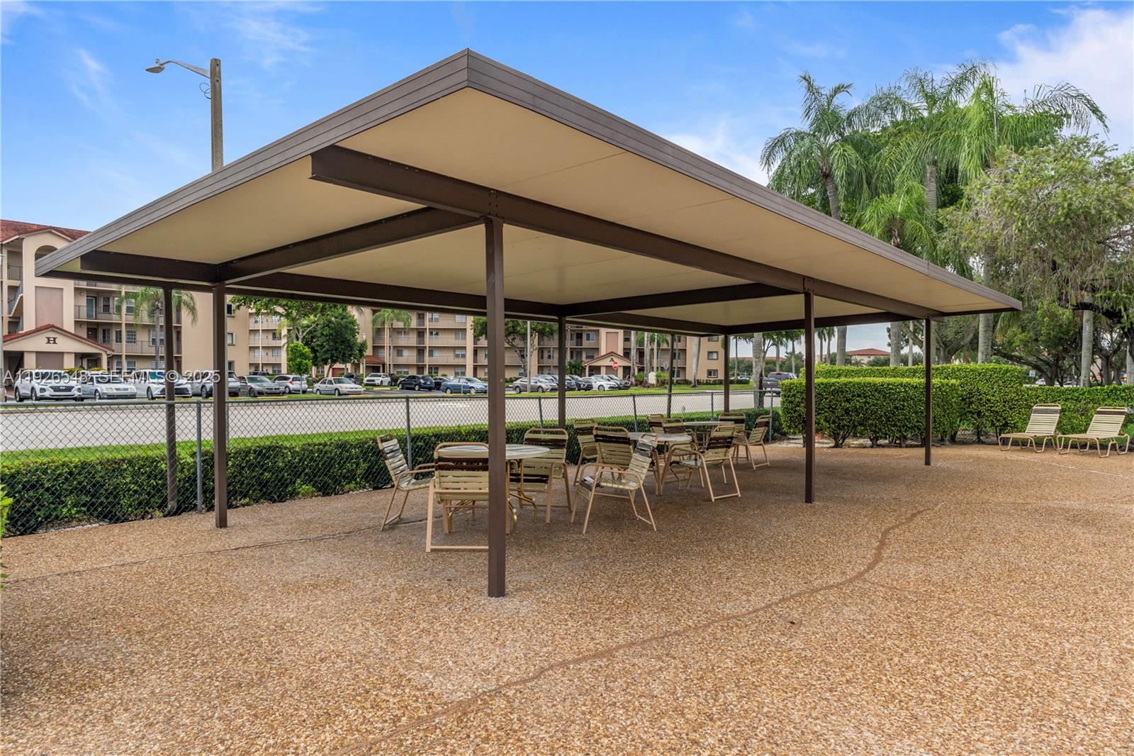 13455 Southwest 9th Court, Unit 216J Pembroke Pines, FL 33027 - Photo 52 of 66 a view of a table and chairs under an umbrella