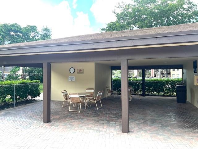13455 Southwest 9th Court, Unit 216J Pembroke Pines, FL 33027 - Photo 56 of 66 a view of a patio with table and chairs potted plants with floor to ceiling window