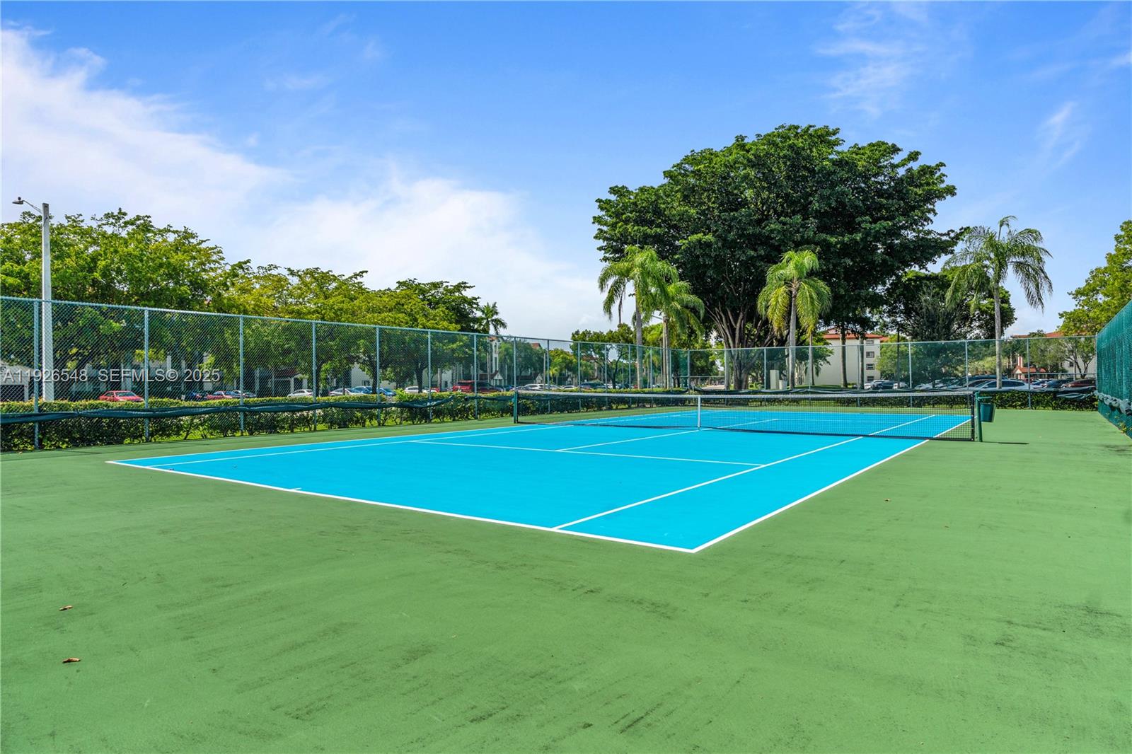 13455 Southwest 9th Court, Unit 216J Pembroke Pines, FL 33027 - Photo 58 of 66 a view of a tennis ground with large trees