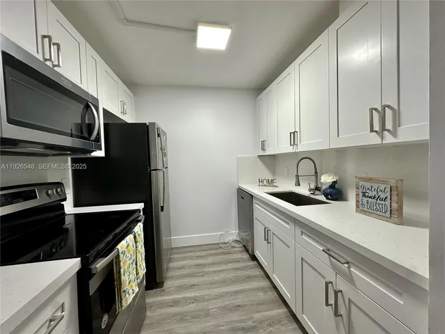 a kitchen with stainless steel appliances a stove a sink and a refrigerator