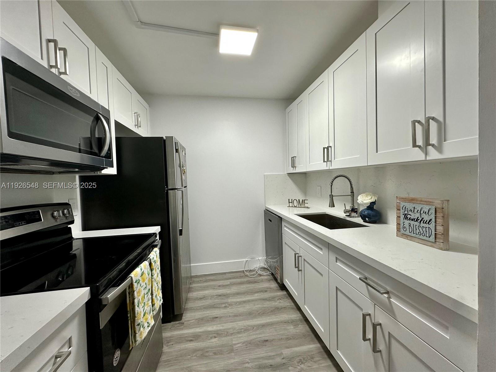 13455 Southwest 9th Court, Unit 216J Pembroke Pines, FL 33027 - Photo 6 of 66 a kitchen with stainless steel appliances a stove a sink and a refrigerator