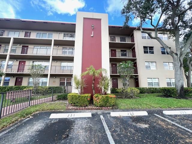 13455 Southwest 9th Court, Unit 216J Pembroke Pines, FL 33027 - Photo 64 of 66 a front view of a building with a garden