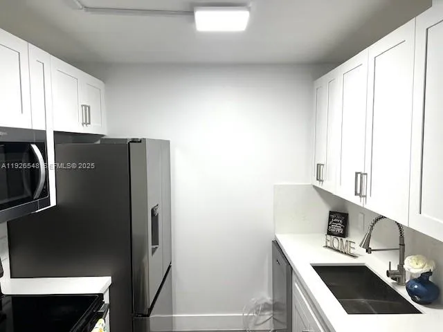 a kitchen with stainless steel appliances a refrigerator sink and stove