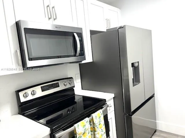 a kitchen with metallic refrigerator and microwave