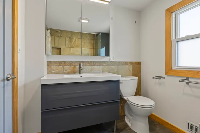 a bathroom with a sink mirror vanity and toilet