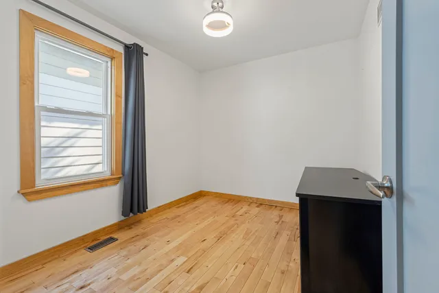 a view of a room with wooden floor and a window