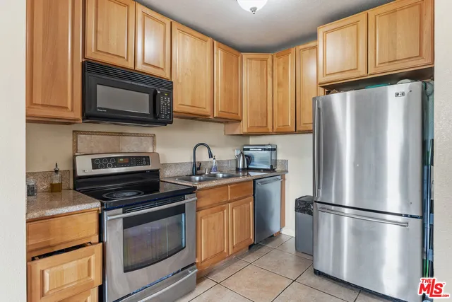 a kitchen with stainless steel appliances granite countertop a refrigerator stove and microwave
