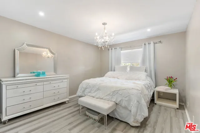 a spacious bedroom with a bed and a dresser