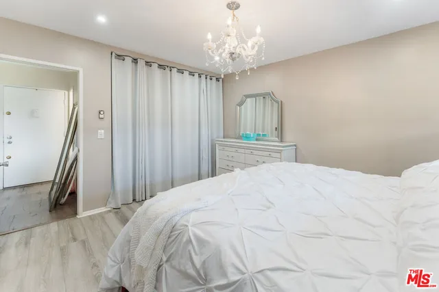 a bedroom with a bed and a chandelier