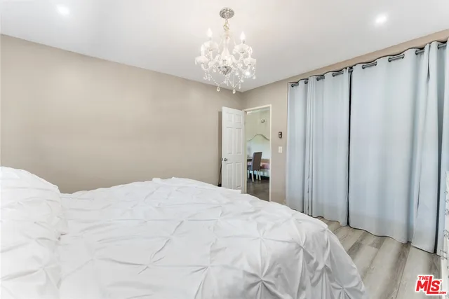 a bedroom with a large bed and a chandelier