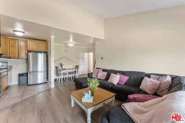 a living room with furniture and a dining table with kitchen view