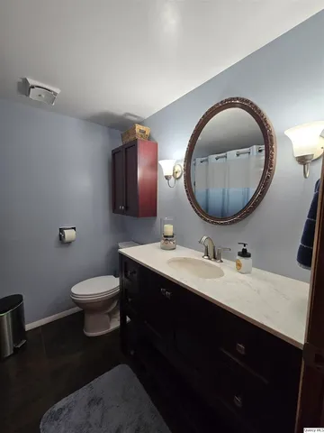 a bathroom with a toilet a sink and mirror