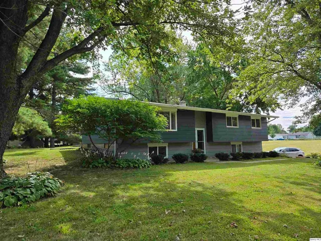 a view of a house with a yard and tree s