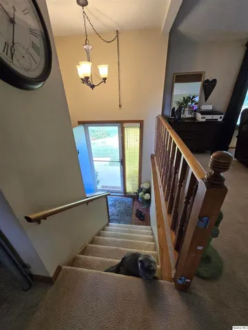 a view of staircase with wooden floor and a chandelier