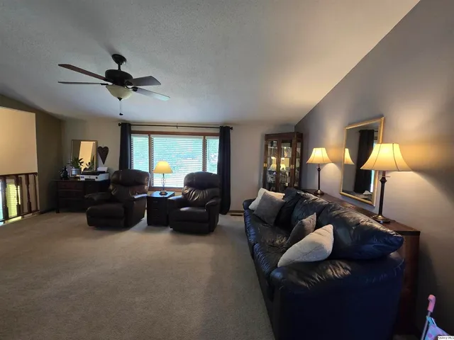 a living room with furniture and a ceiling fan