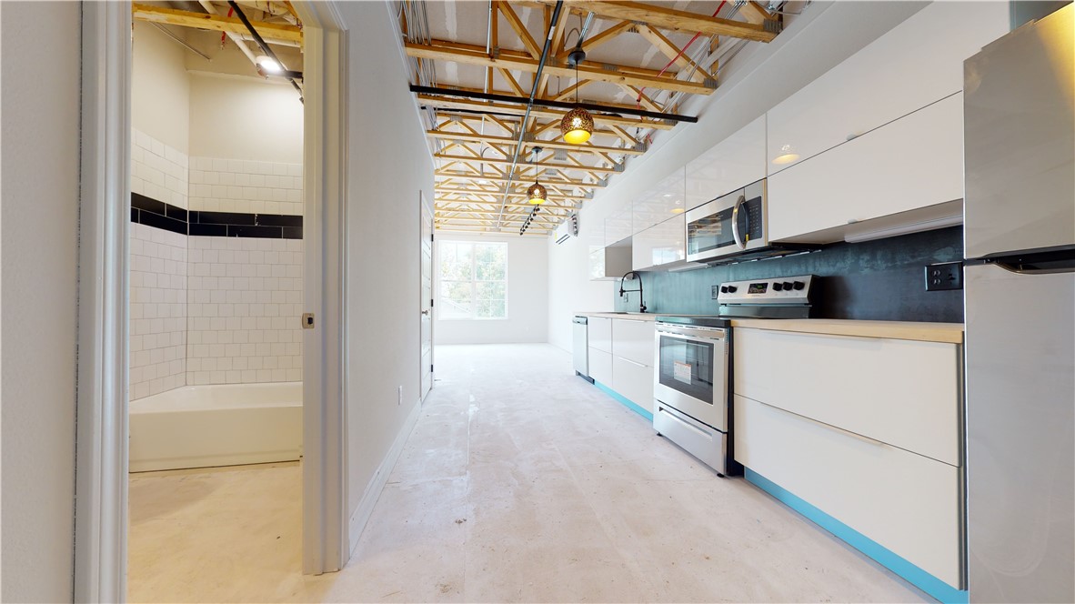 305 West 27th Street, Unit 228 Bryan, TX 77803 - Photo 3 of 17 a kitchen with stainless steel appliances a refrigerator and a stove