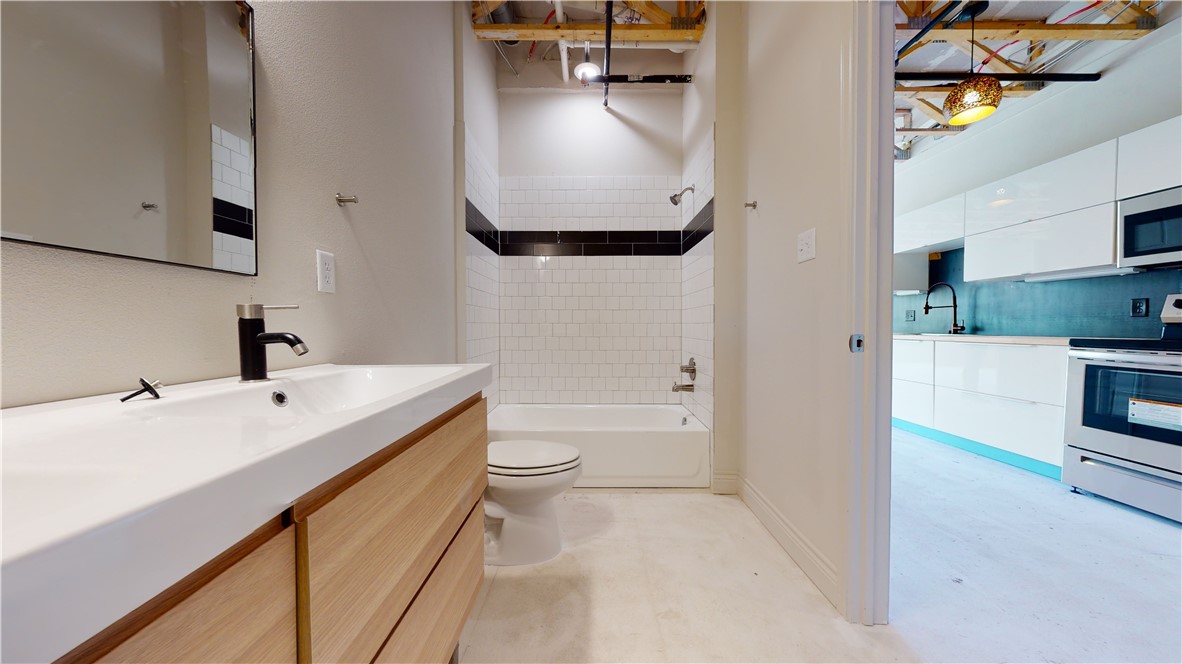 305 West 27th Street, Unit 228 Bryan, TX 77803 - Photo 8 of 17 a en suite bathroom with a sink a toilet and a mirror